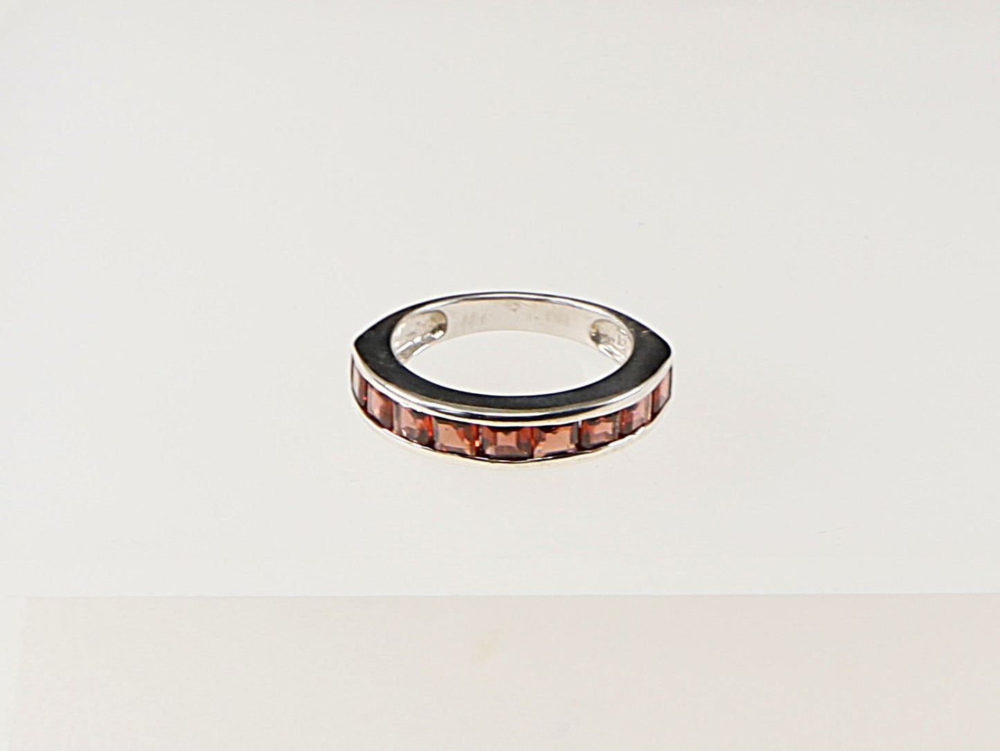 This lovely Sterling Silver Garnet band ring has 9 square cut channel set Garnets.
It is in great condition and has 925 stamped on the inside of the band for Sterling Silver.
UK Finger size: N 1/2