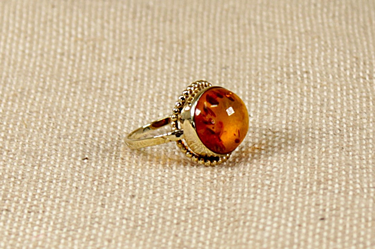 This stunning vintage ring has a round cabochon Amber set in a finely made Gold setting. The Amber is displaying inside many Fossils trapped in time.
The ring is stamped 333 inside the band for 8ct Gold. In our opinion this ring is circa 1930’s and possibly continental in origin. UK Finger size N.