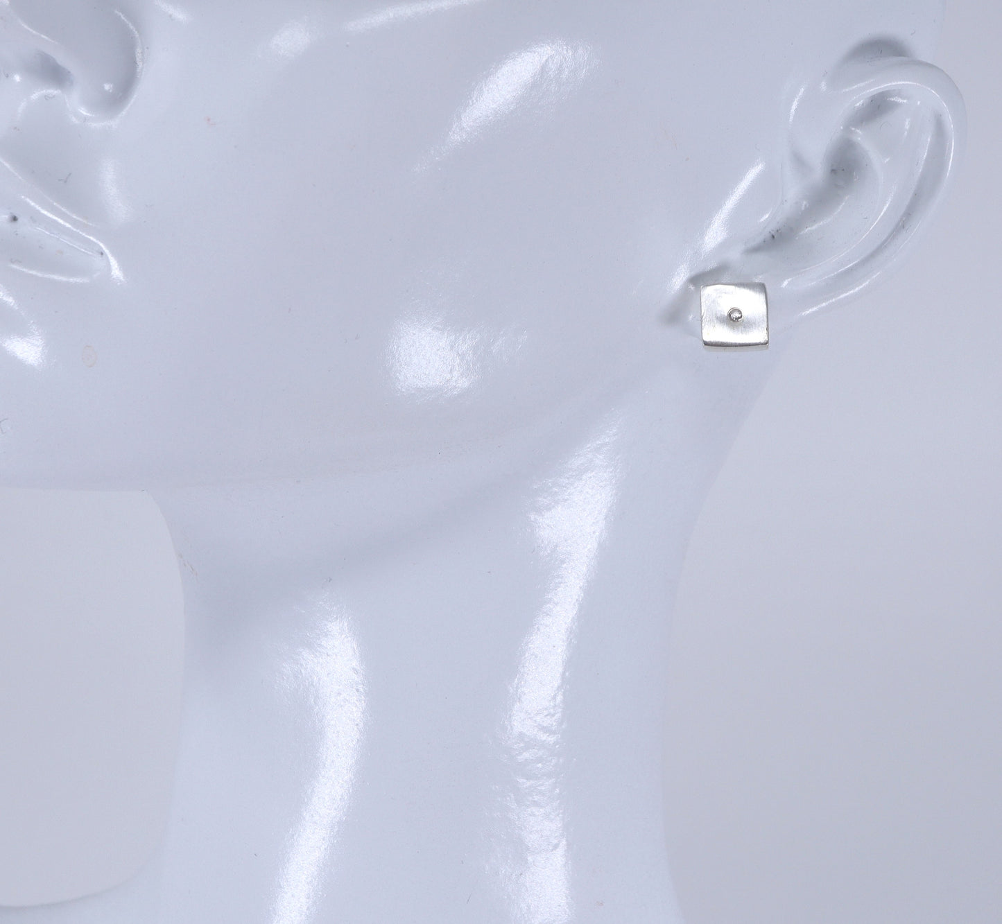Close-up of a silver earring on a white background