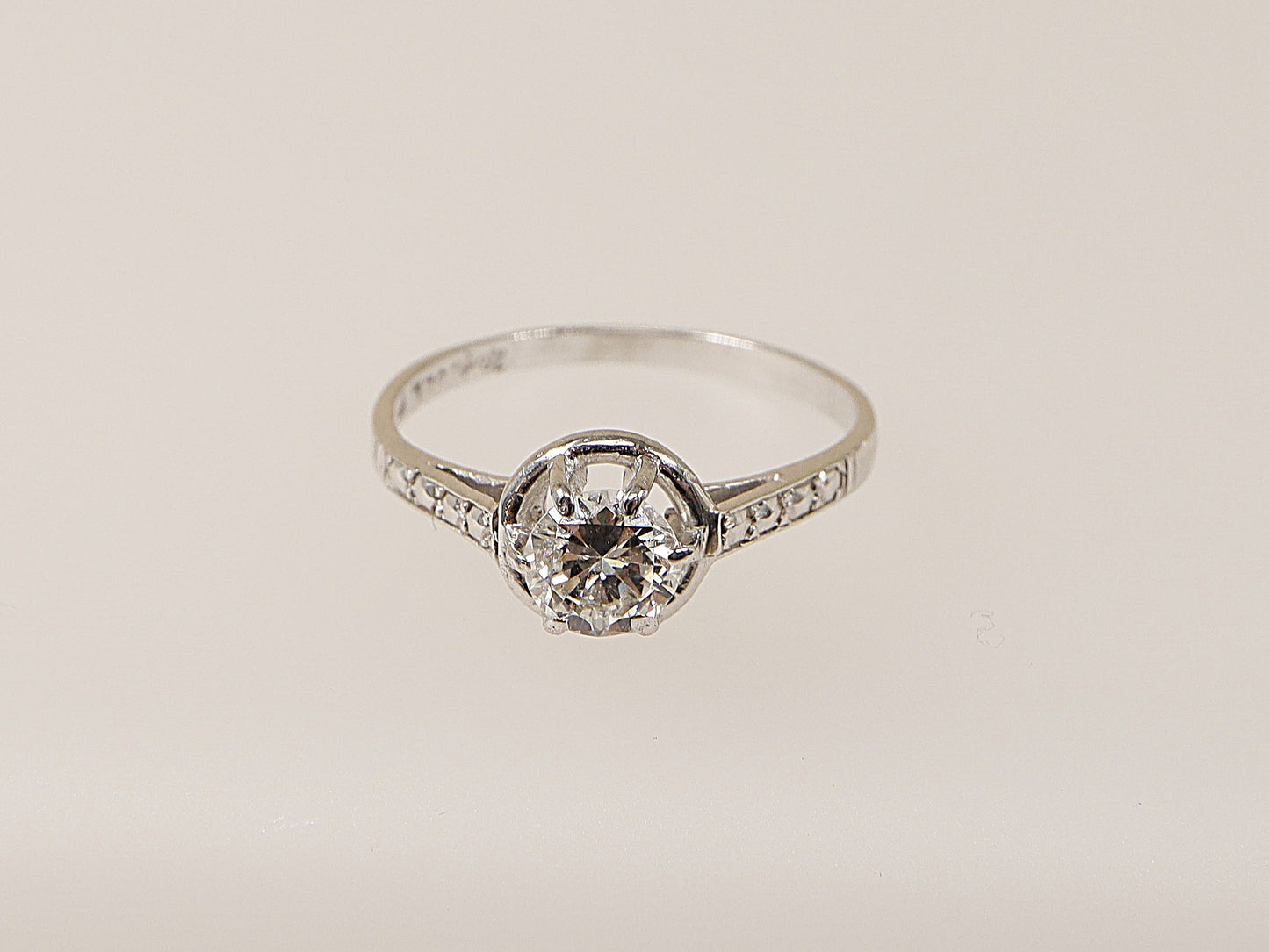 An 18ct white gold diamond solitaire ring with a central diamond set in a six-claw crown setting, surrounded by smaller diamonds on the shoulders. This ring would make an ideal engagement ring for your loved one!
Diamond diameter: 5mm, Diamond weight: 0.50ct (estimated), UK Finger size N.