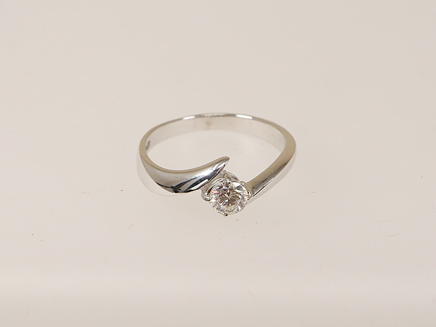 An 18ct white gold diamond solitaire ring with a twist design and a central diamond held by a four claw setting. is the perfect engagement ring! UK Finger size R. Diamond weight: 0.45ct (estimated).