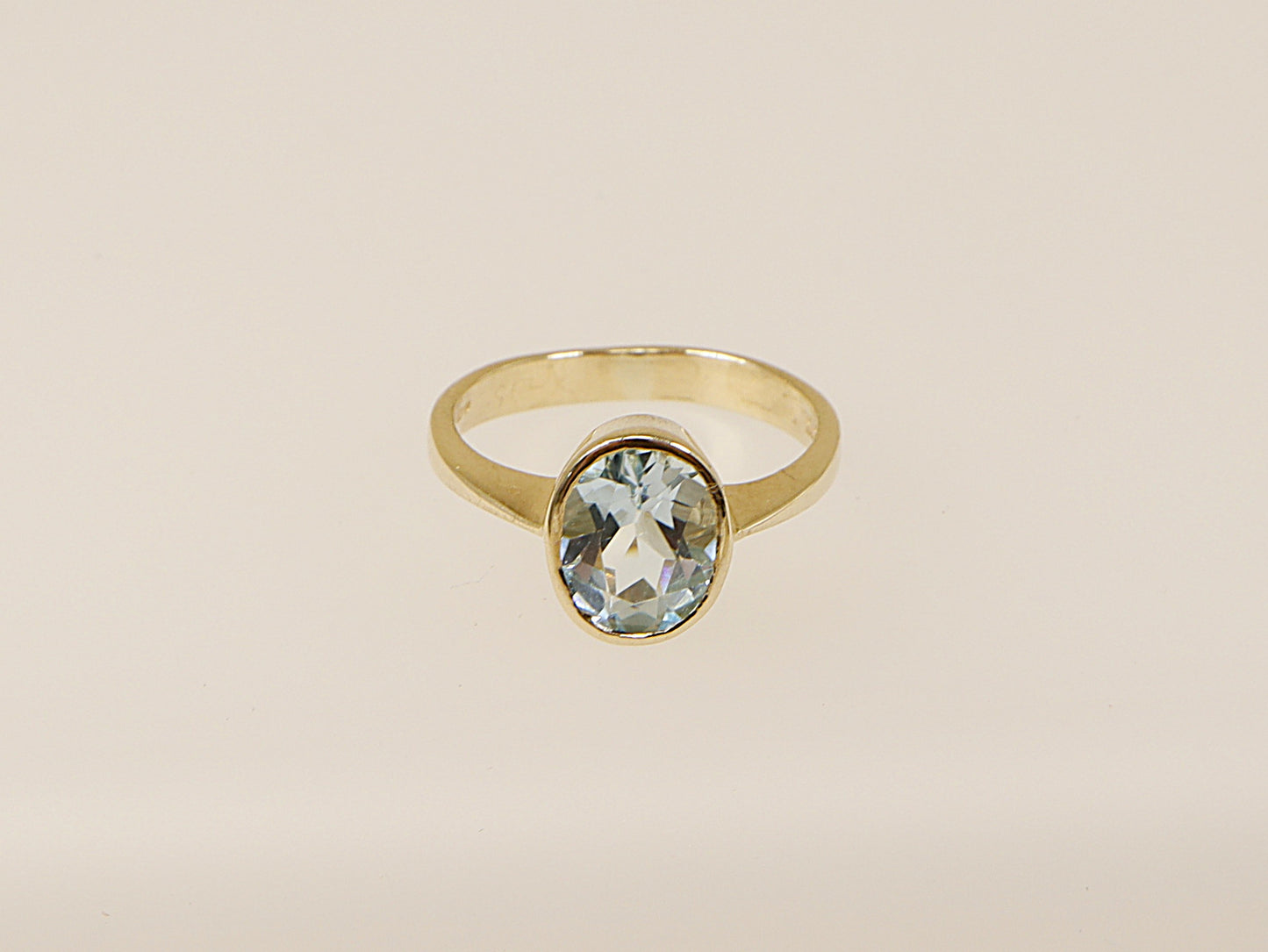 A vintage 9ct gold solitaire ring with an oval-cut blue topaz gemstone.