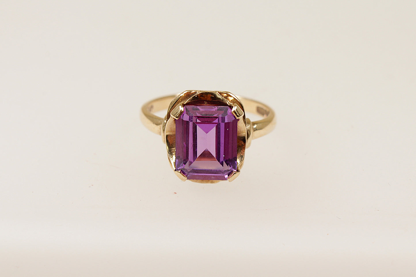 This stunning vintage ring combines both boldness and elegance. Handcrafted in 9ct Gold it showcases a rich purple Amethyst, emerald cut, that gives it a sophisticated and regal look.
The robust 4 claw design has a striking visual impact and the unique boldness of the crown setting elevates it beyond a traditional solitaire style.
It is in excellent condition and has Glasgow hallmarks for 1939, UK finger size N.