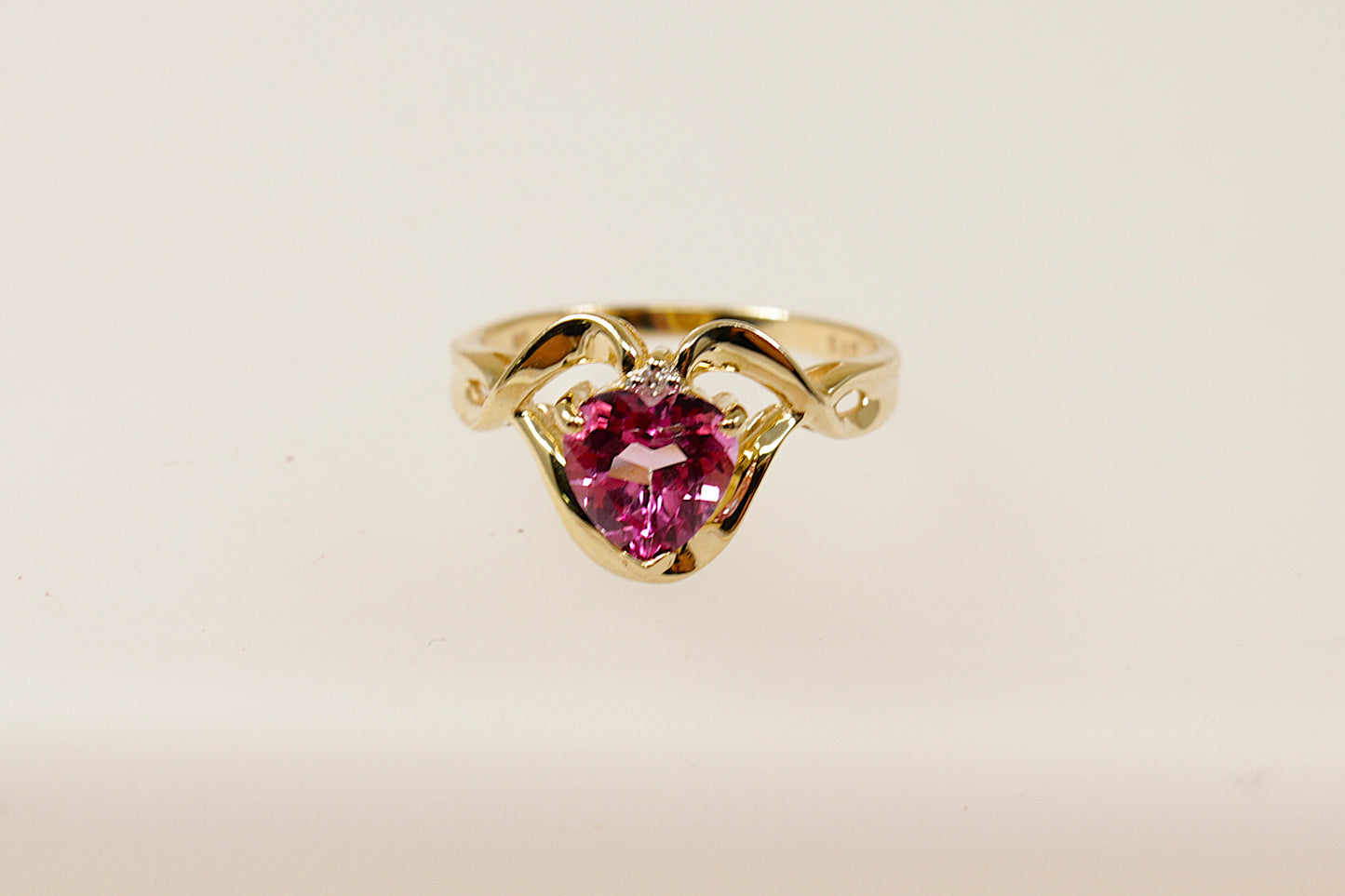 This charming 9ct Gold and heart shaped Pink Topaz ring is a romantic piece, perfect for that special occasion.
The delicate and elegant design showcases a Pink Topaz heart with a single diamond accent adding extra sparkle. Ornate Gold detailing surround the Topaz gemstone, this intricate craftsmanship adds texture and dimension to the ring enhancing its romantic appeal. UK finger size N.