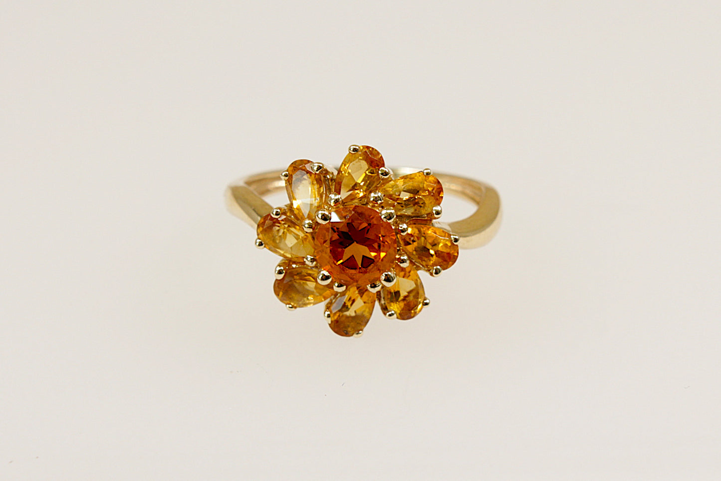 A 9ct gold ring with a flower design, featuring teardrop and round citrines.