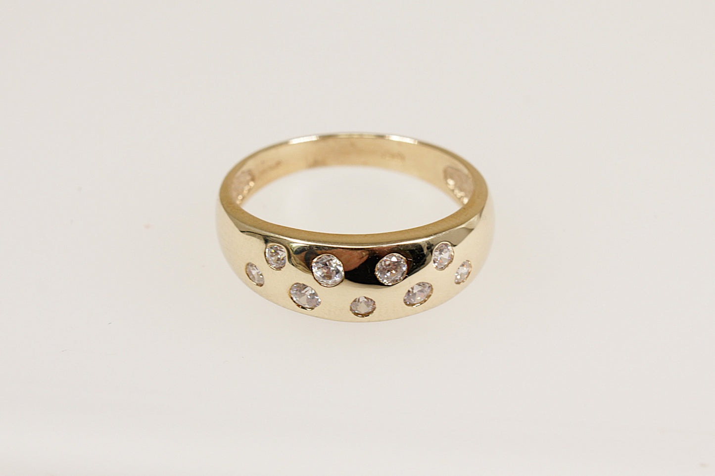 A 9ct yellow gold ring with a series of round-cut white crystals set in two staggered rows on the top.