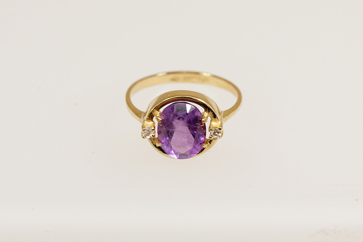 An 18ct yellow gold amethyst solitaire ring the Amethyst is flanked a round cut diamond on each side, the ring is stamped 750 for 18ct gold, UK finger size L.