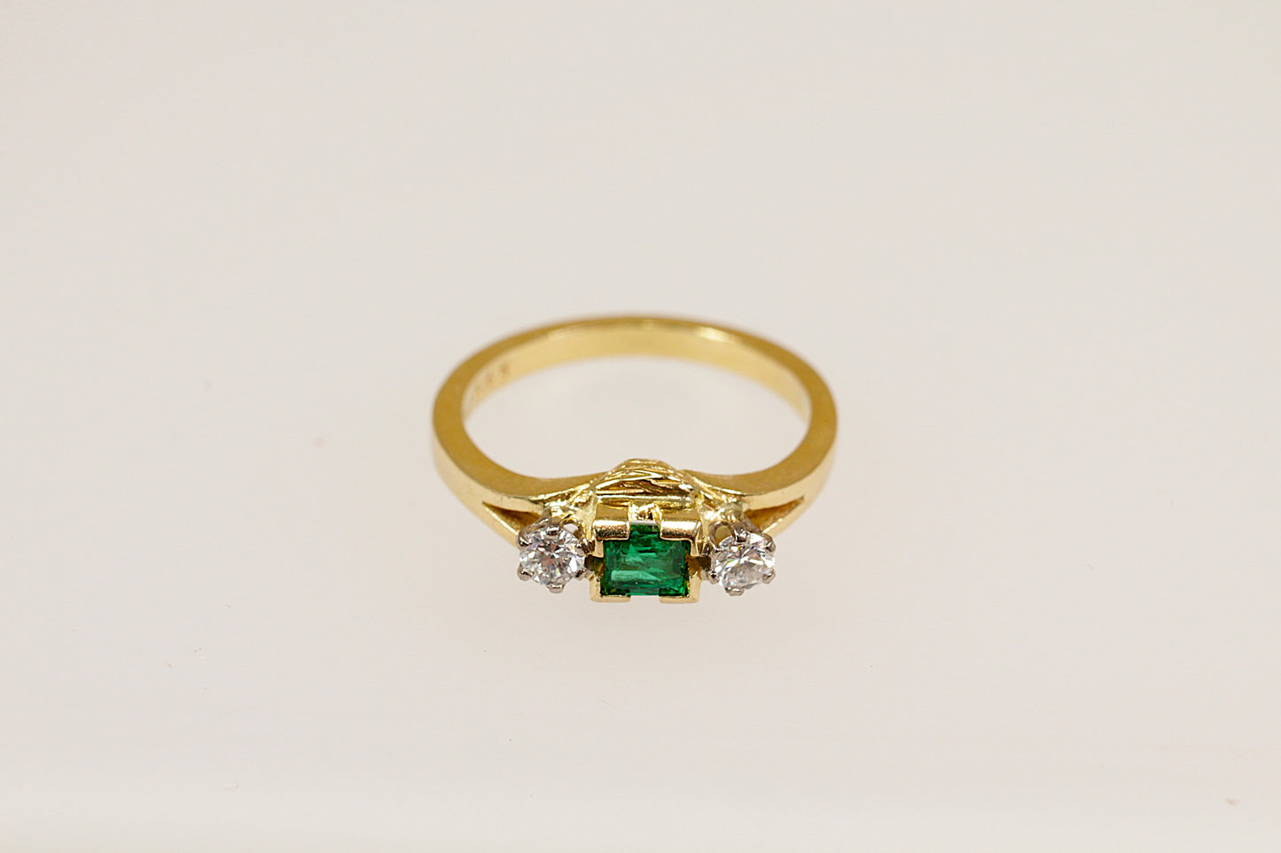 18ct yellow gold emerald and diamond trilogy ring.