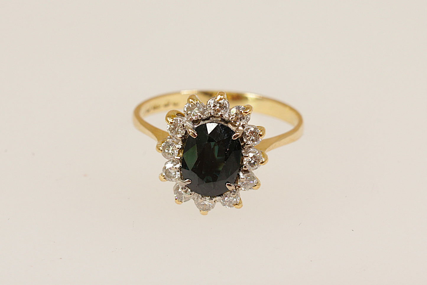 18ct yellow gold sapphire and diamond ring in the classic 'princess diana' style this beautiful ring has a 1.25 carat (estimated) blue sapphire surrounded with a halo of 12 sparkling round cut diamonds UK finger size N.