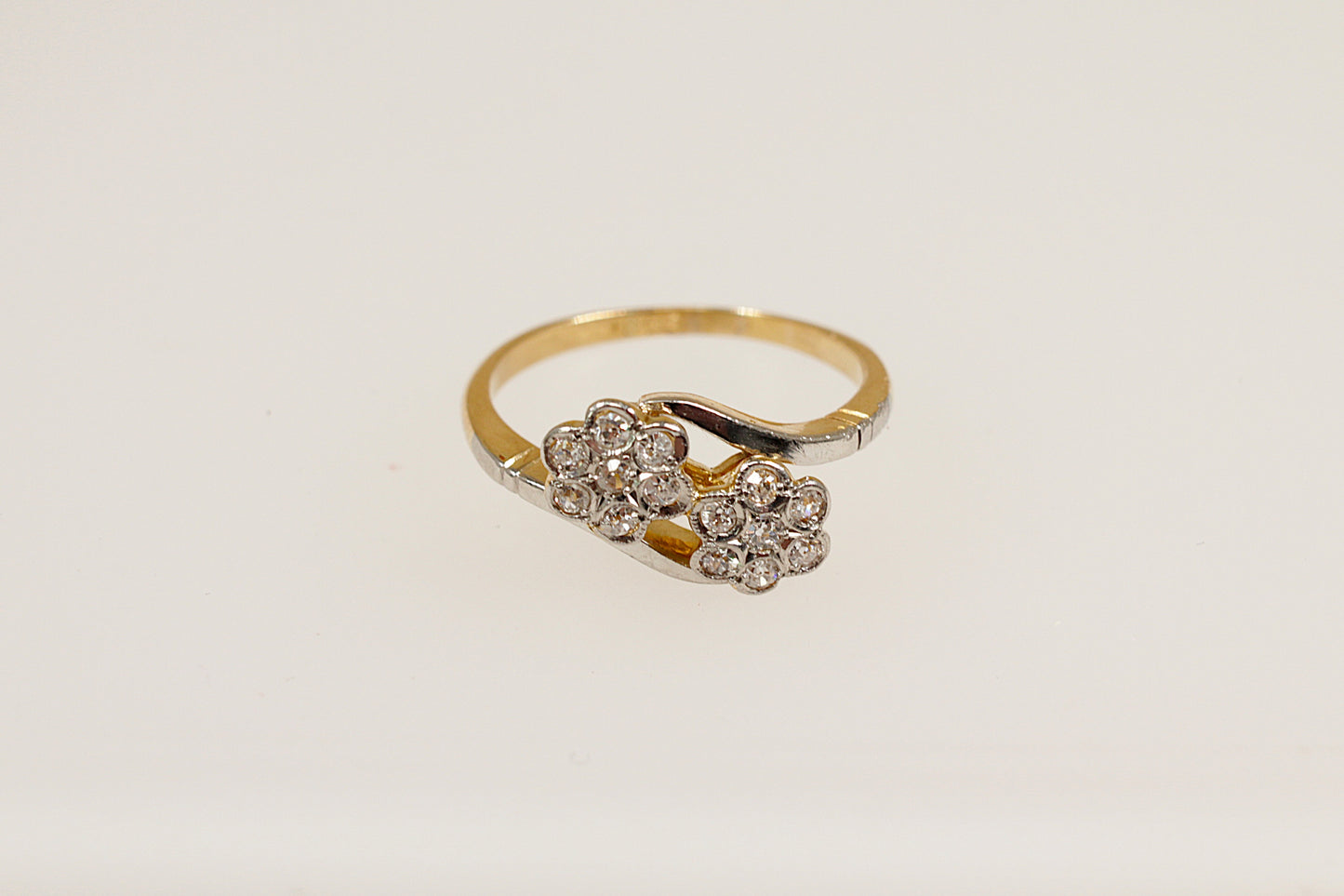A vintage 18ct gold diamond cluster ring with a duo of daisy flower heads design, featuring multiple diamonds.