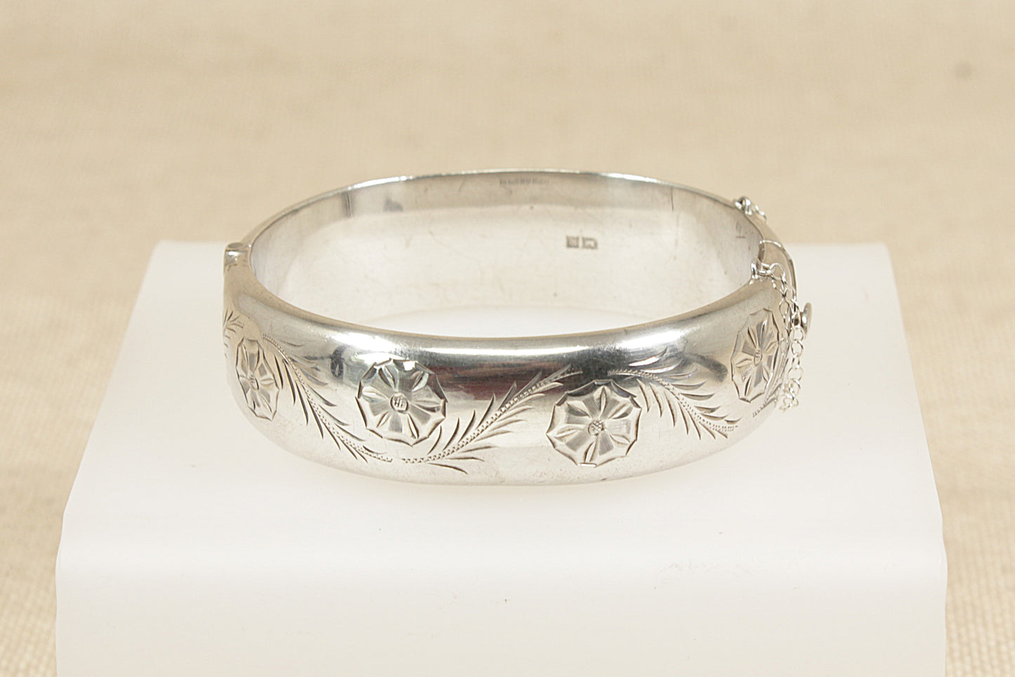 Vintage sterling silver hinged bracelet bangle with floral etching and safety chain the bangle has secure fastening with Birmingham hallmarks and the year date letter for 1966.