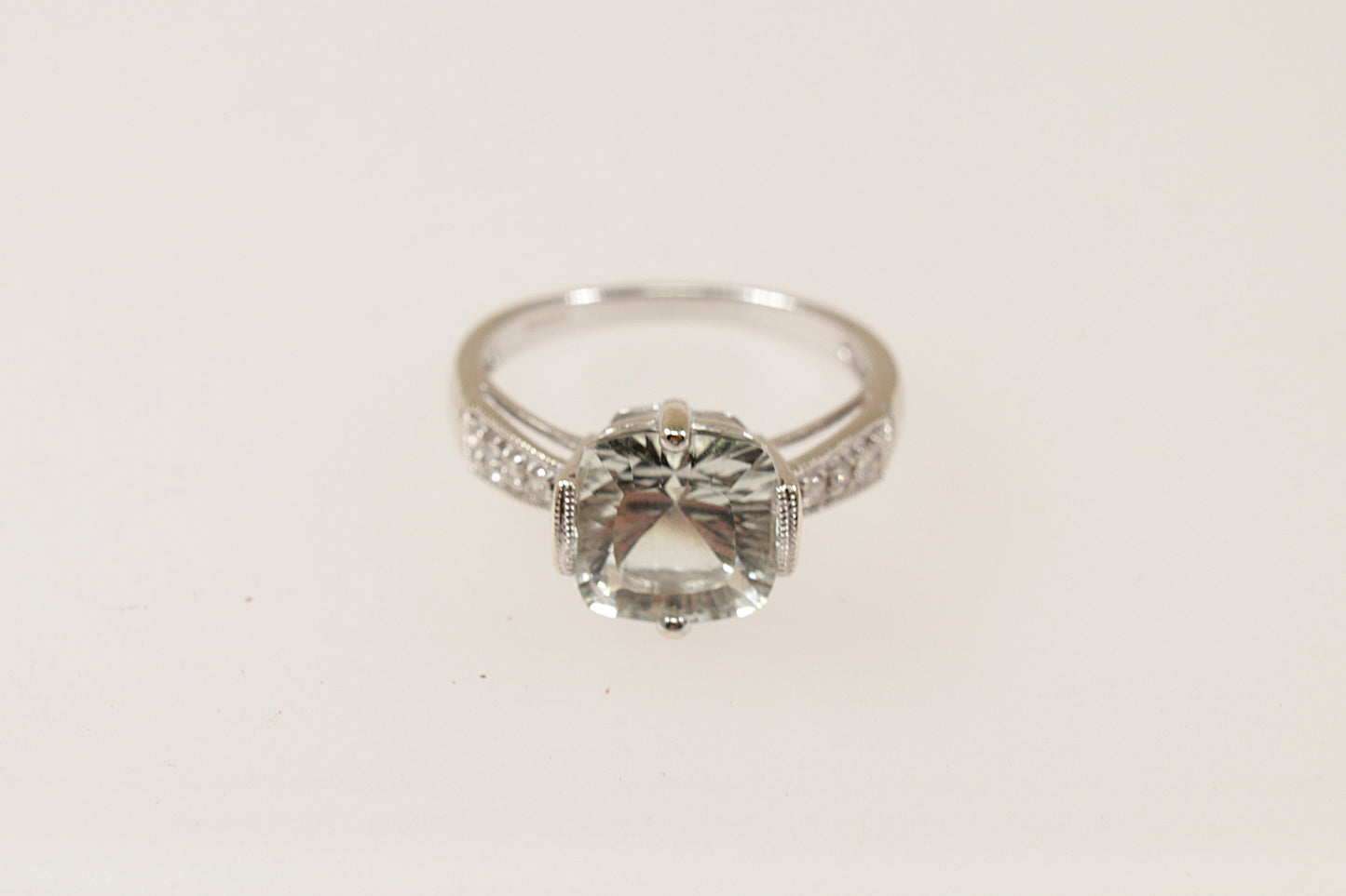 A 9ct White Gold large cushion cut pale green Citrine, Each shoulder has 3 Diamond accents, enhancing the ring’s brilliance, inside the band it has Birmingham hallmarks for 2008, UK Finger size: O.