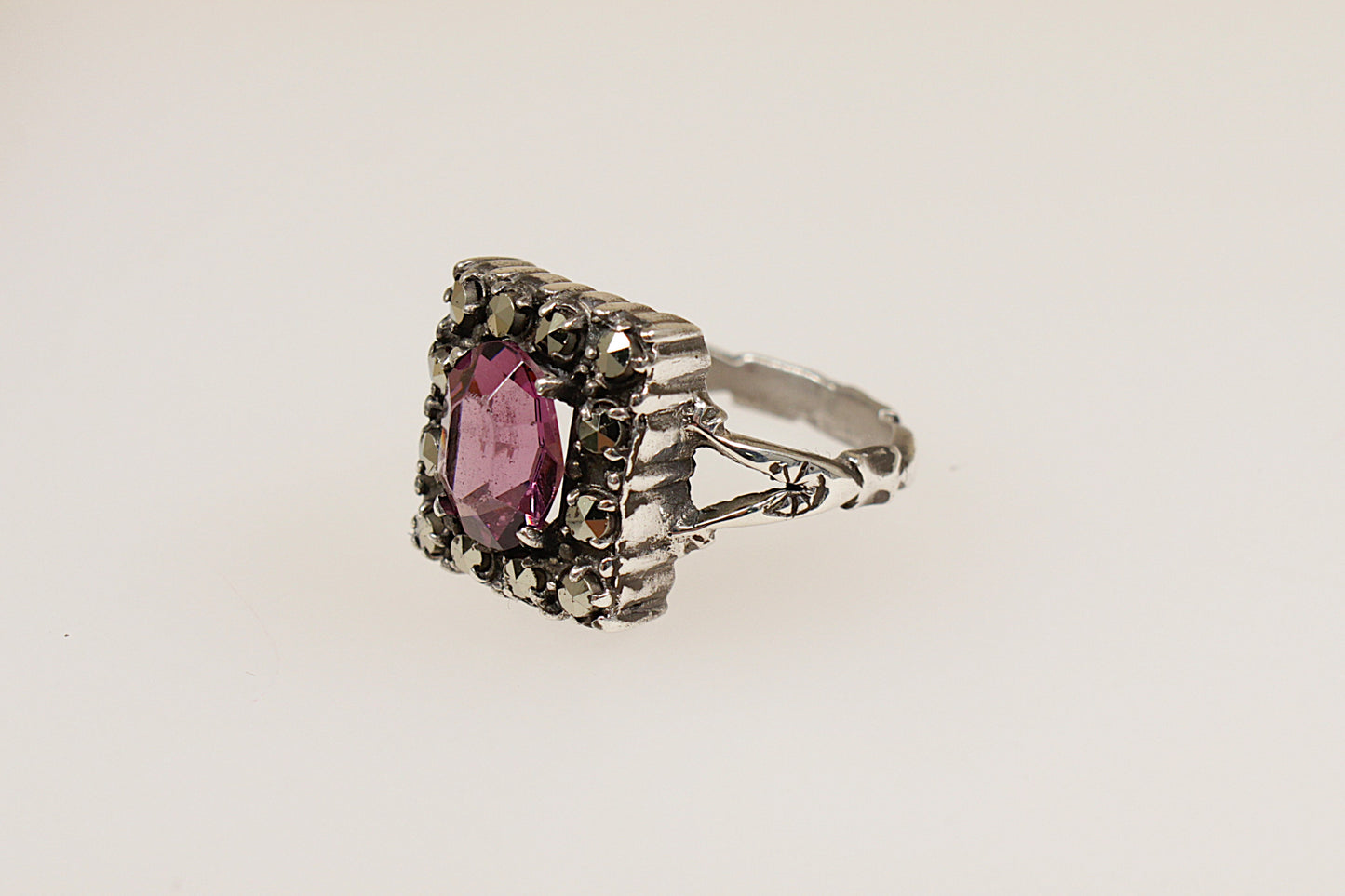 This stunning Silver, Art Deco ring with Amethyst coloured paste stone, combines vintage charm with sophisticated detail. It is in excellent condition and inside the band it is stamped Silver. UK Finger size N.