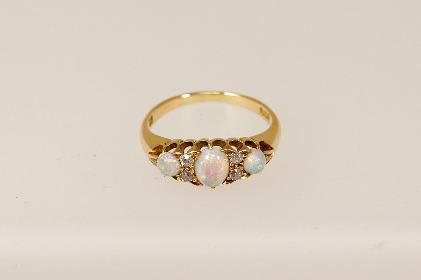 An Edwardian 18ct gold ring with three cabochon cut fire opals and four rose cut diamonds set in a galleried design, The ring is in excellent condition and inside the band it is stamped 18 for 18ct Gold. It also has the maker mark A & W.
UK Finger size P.