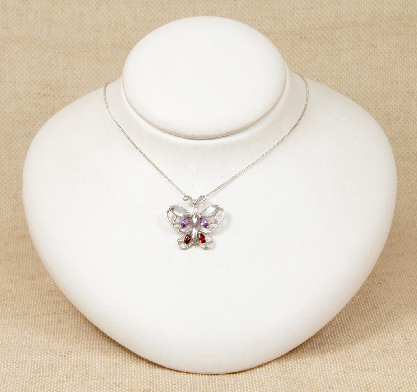 Silver Multi Gemstone, Diamond Butterfly Pendant and a Chain Necklace.
This beautiful Silver butterfly pendant has 6 coloured gemstones comprising of Blue Topaz, Amethyst and Garnet with a petite Diamond on the head of the butterfly. The pendant is stamped 925 for sterling silver and DIA for diamond on the back of the pendant.
The pendant sits on an 18 inch silver trace chain.