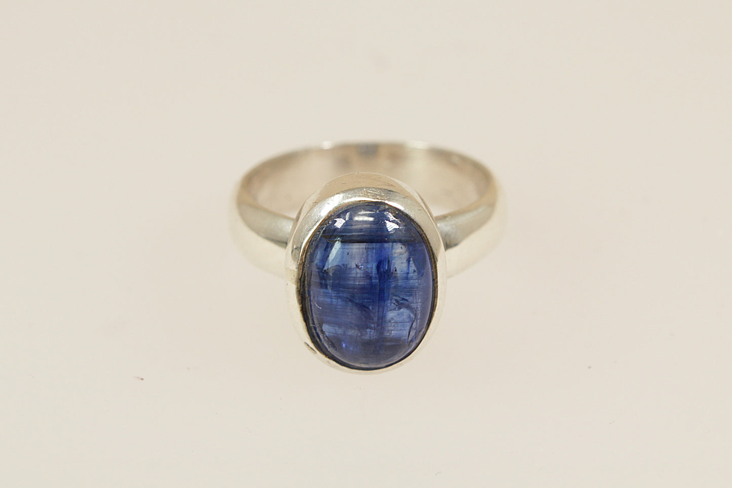 A striking sterling silver ring featuring a smooth, cabochon-cut blue topaz in a sleek bezel setting, male or female, uk finger size O.