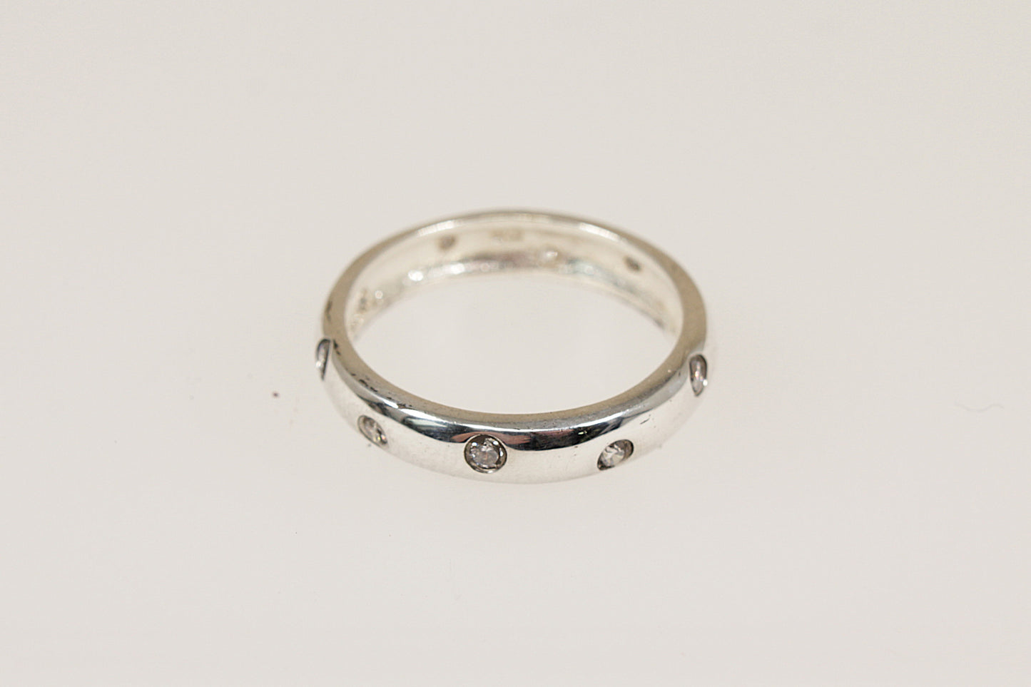 This stylish and elegant band ring has inset crystals running all around the band, combined with the rounded edges, this creates a modern yet timeless look. The polished smooth finish provides a comfortable feel for everyday wear and it would make a perfect stacking ring. It is stamped 925 for sterling silver.