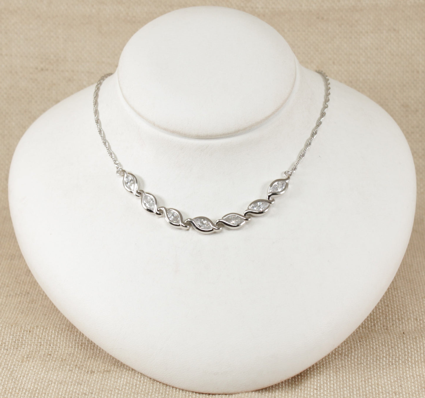 This stunning necklet has 7 marquise cut sparkly Cubic Zirconia gemstones set in handcrafted silver. Each link has a marquise shape silver design setting to match the CZ gemstone. At each end of the links is a fancy twist design silver chain. It is in excellent condition, stamped 925 for sterling silver. Total length : 16 ½ inches.
