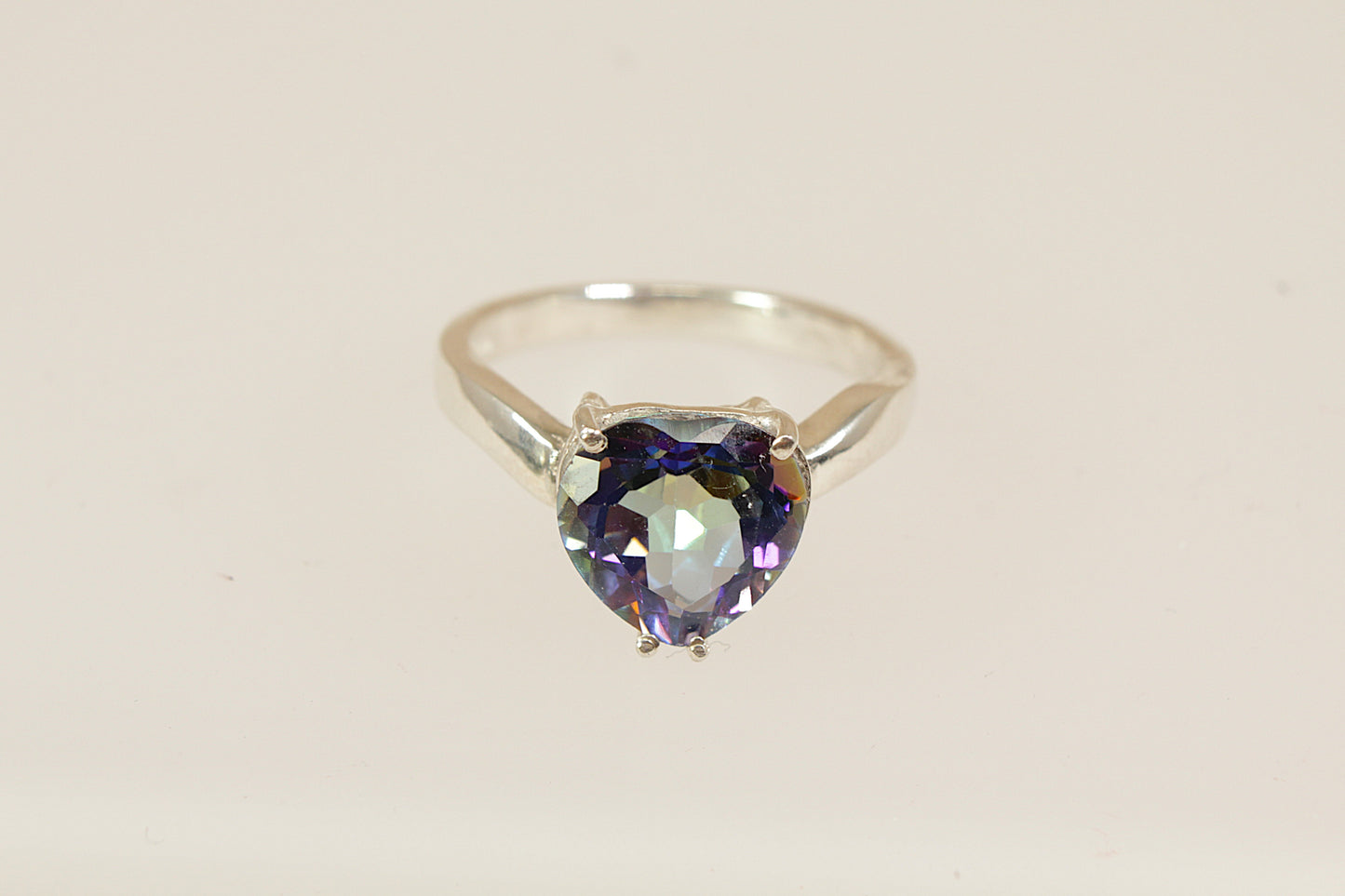 A lovely and eye-catching sterling silver statement ring featuring a dazzling heart-shaped mystic blue topaz as the centrepiece. The stone shimmers with enchanting iridescent tones, ranging from deep blue to flashes of green and violet, depending on the light. UK finger sie P.
