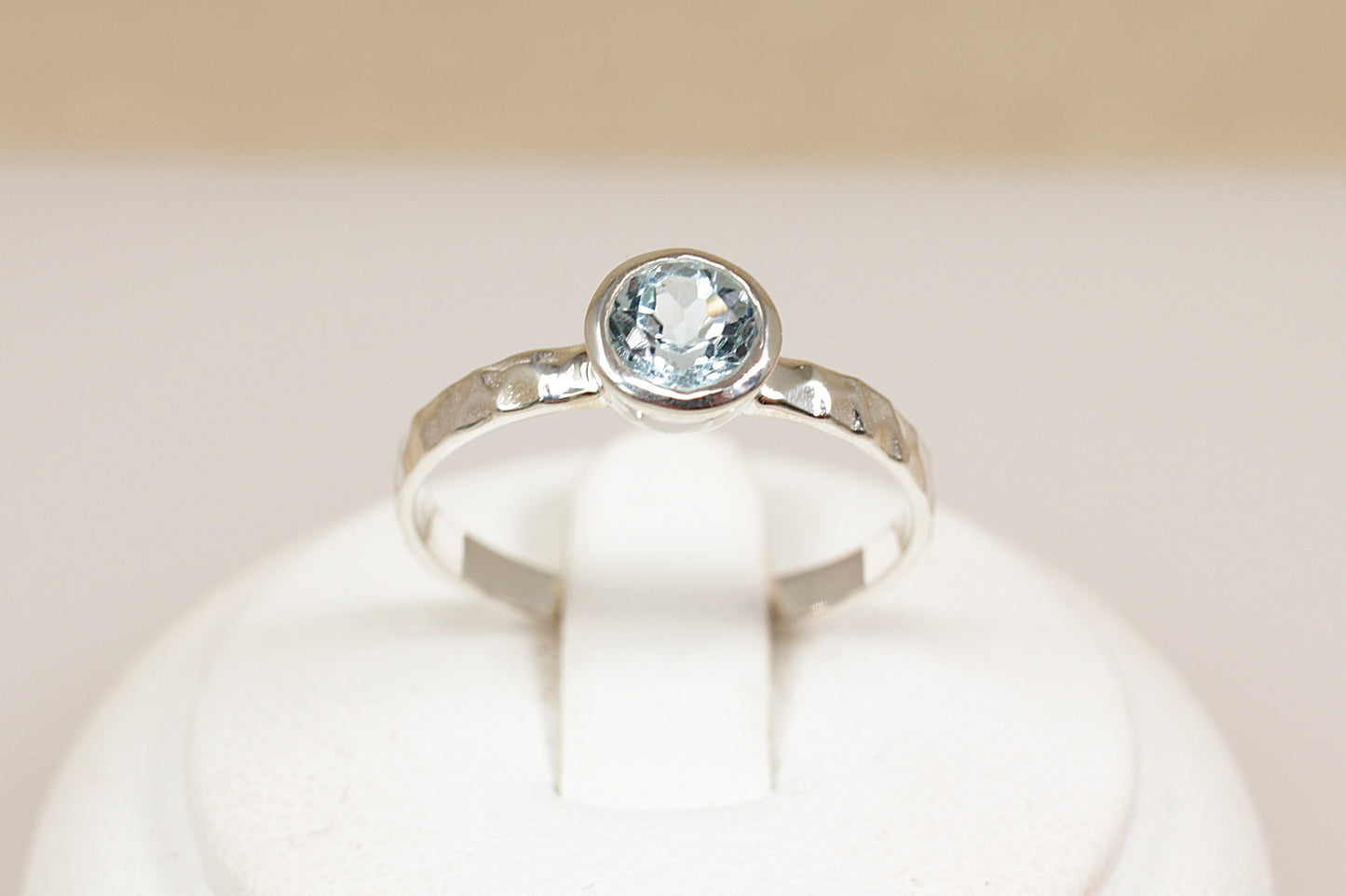 Silver ring with a blue gemstone on a white background