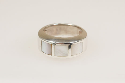 A vintage sterling silver band ring with mother of pearl inlays, viewed from the top with a white background.