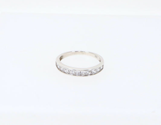 A sterling silver half eternity ring with 11 channel set princess cut cubic zirconia gemstones. Cubic Zirconia has all the style and elegance of a real diamonds, looks just like the genuine item, add some affordable sparkle. The ring is stamped 925 inside the band for sterling silver. UK finger size R.