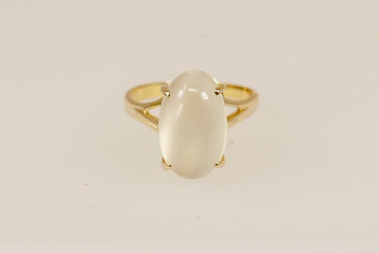 A truly enchanting 14ct Gold solitaire ring, showcasing a large, luminous cabochon-cut Moonstone that glows with soft, ethereal shimmer. The gemstone is held securely by four bold claws, rising from a basket-style setting that adds depth and classic elegance to the design, Inside the band, it is clearly stamped 585, confirming its 14ct gold purity, UK Finger size: N.