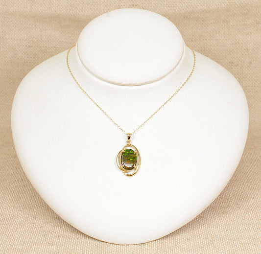 Gold necklace with a opal pendant on a white mannequin bust against a beige background