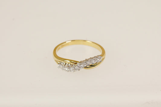 This beautifully crafted 18ct gold half eternity ring features a graceful crossover design, forming a soft wave or 'S' shape that flows elegantly across the finger. Set with nine round brilliant-cut diamonds. The inside of the band the ring has Birmingham assay marks for 18ct gold, along with the date letter for 1994. UK finger size O.