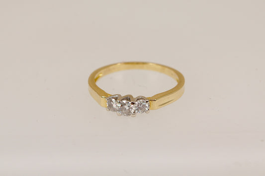18ct Gold trilogy ring with three diamonds on a light beige background