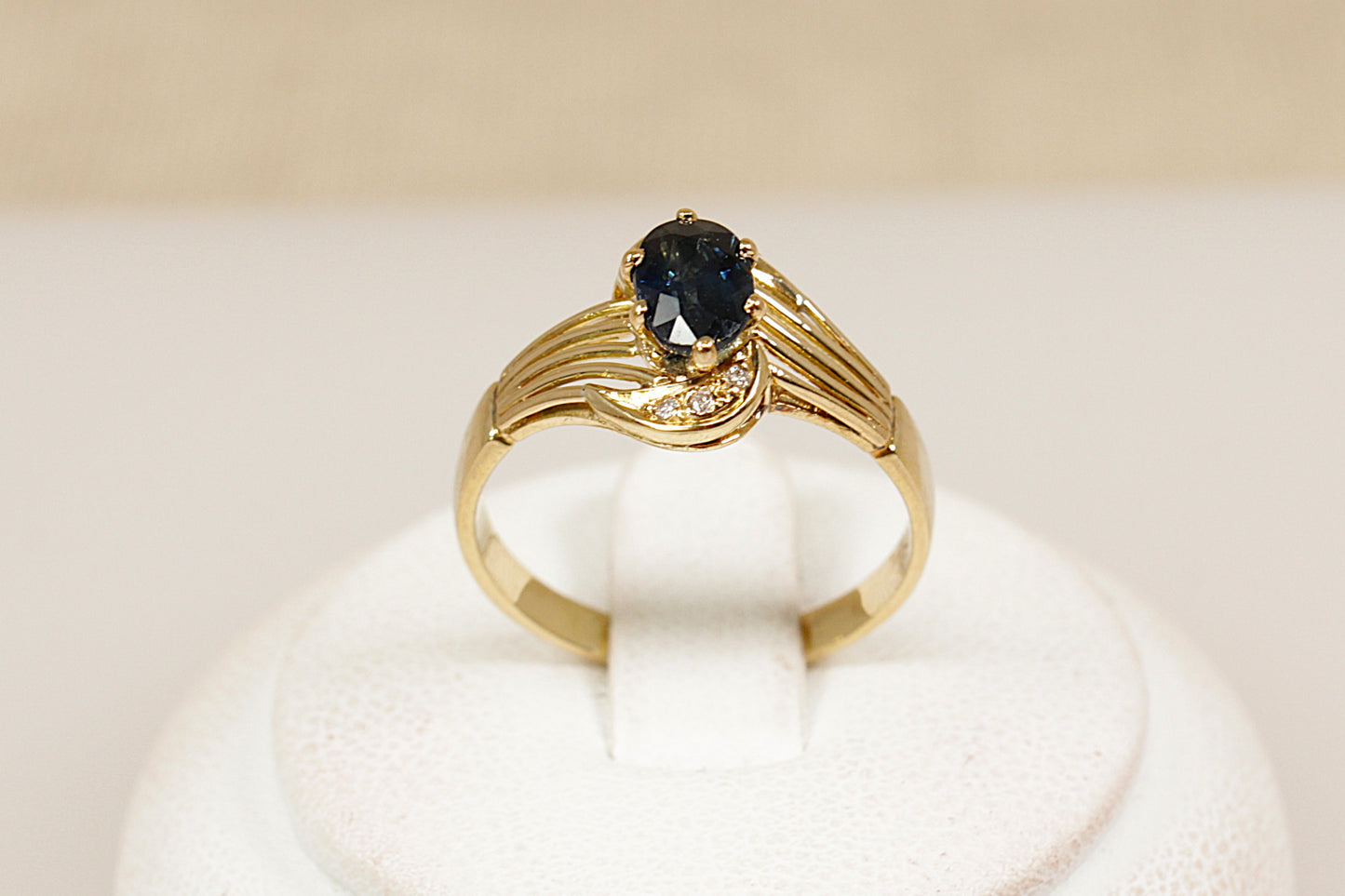 18ct yellow gold sapphire and diamond solitaire ring, the centre rich blue sapphire is approximately 0.60 carat in weight with three diamonds top and bottom of the gemstone, UK finger size N.