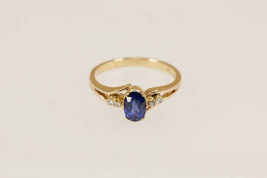 18ct yellow gold solitaire ring with a beautiful royal blue oval sapphire of approximately 0.50carat adorned by two round cut diamonds on each shoulder UK finger size L.
