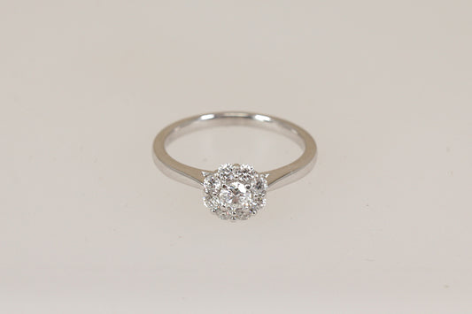 Certified Diamond daisy cluster ring on a light beige background