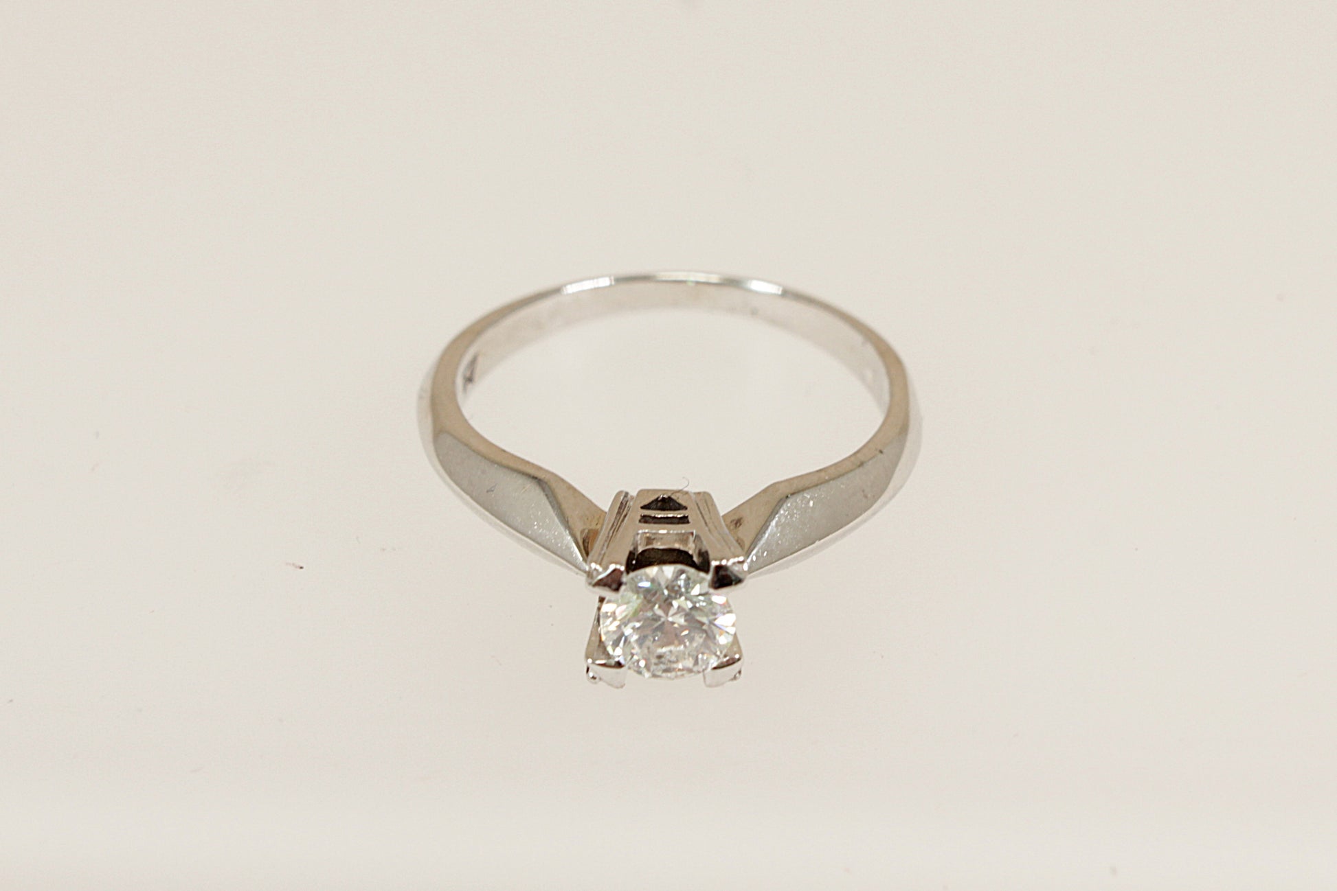 This beautiful, elegant 18ct white gold solitaire ring features a brilliant 0.50ct (estimated) round diamond, securely held in a robust four-claw crown setting. Inside the band, the ring is stamped "750" for 18ct gold and bears the distinctive WM maker’s mark, perfect as an engagement ring or as a classic addition to any fine jewellery collection. UK finger size N.