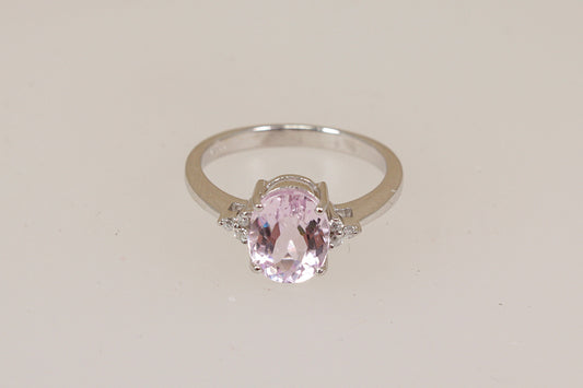 White 18ct gold ring with a pink Kunzite gemstone with diamond accents on a light beige background