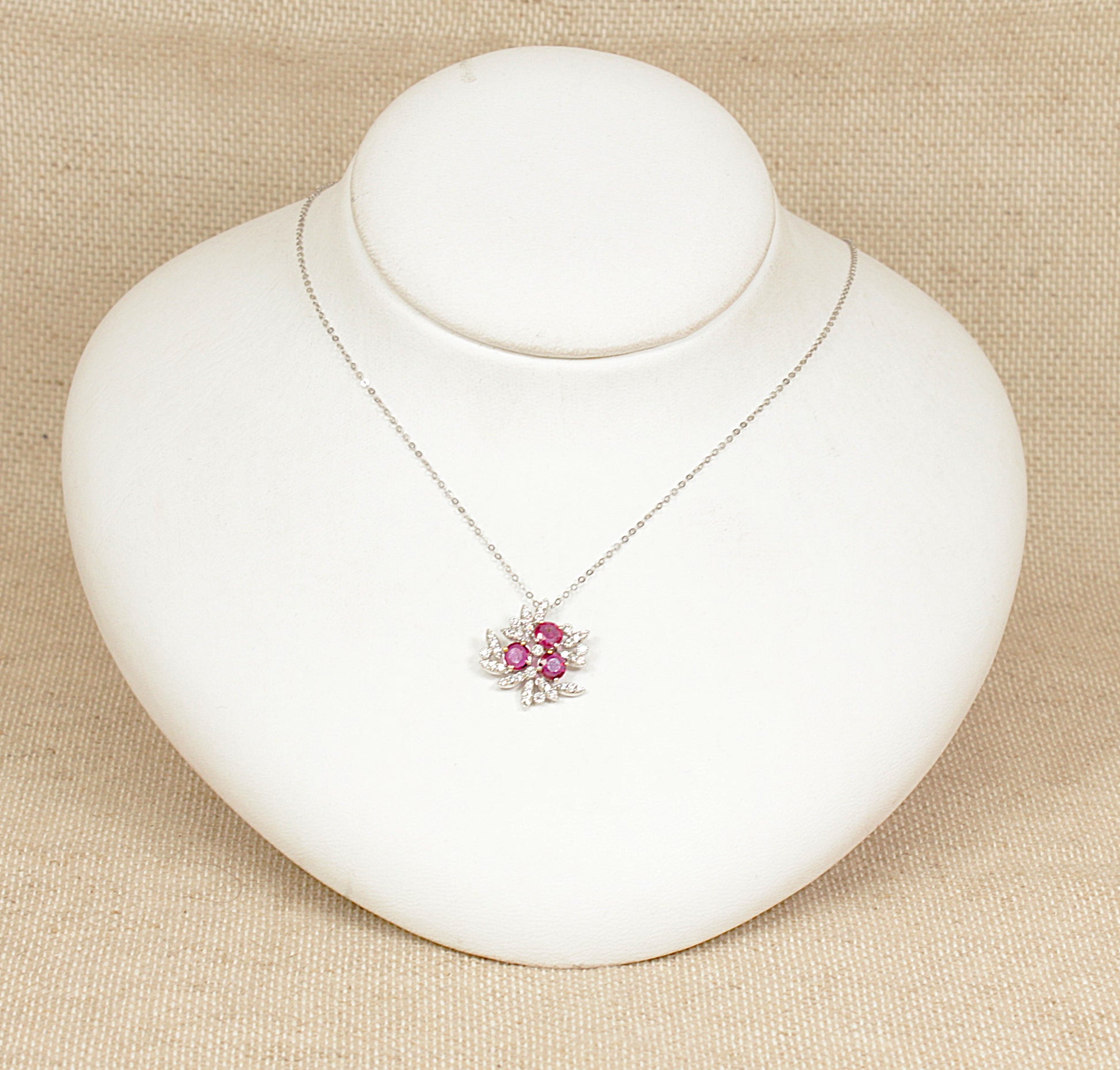 18ct white gold diamond and ruby pendant necklace stamped 0.93 carat for the rubies and 0.32 carat for the diamonds the pendant sits on a 18ct white gold 18 inch chain.