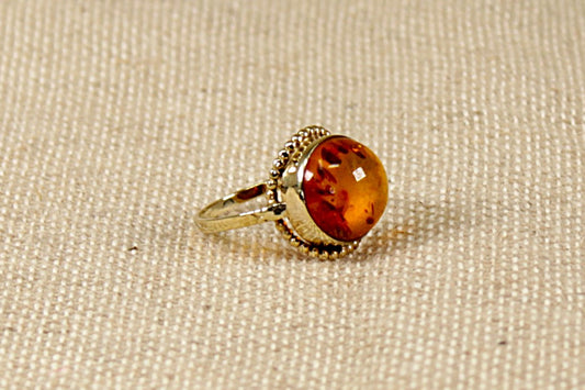 This stunning vintage ring has a round cabochon Amber set in a finely made Gold setting. The Amber is displaying inside many Fossils trapped in time. 
The ring is stamped 333 inside the band for 8ct Gold. In our opinion this ring is circa 1930’s and possibly continental in origin. UK Finger size N.
