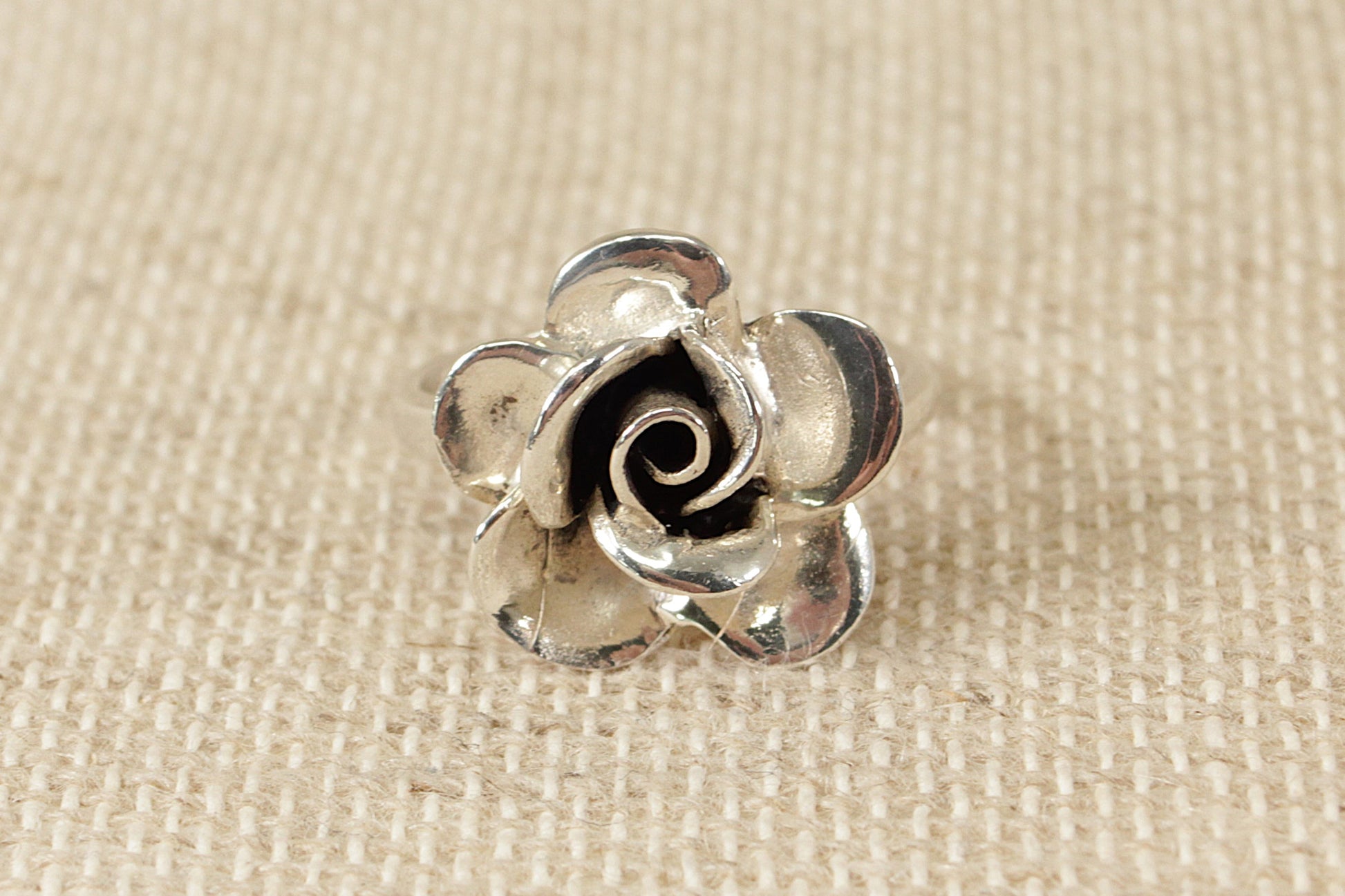 This stylish and beautifully handcrafted silver ring is in the shape of a rose and is finely made. Inside the band it is stamped 925 for sterling silver. UK Finger size: O.