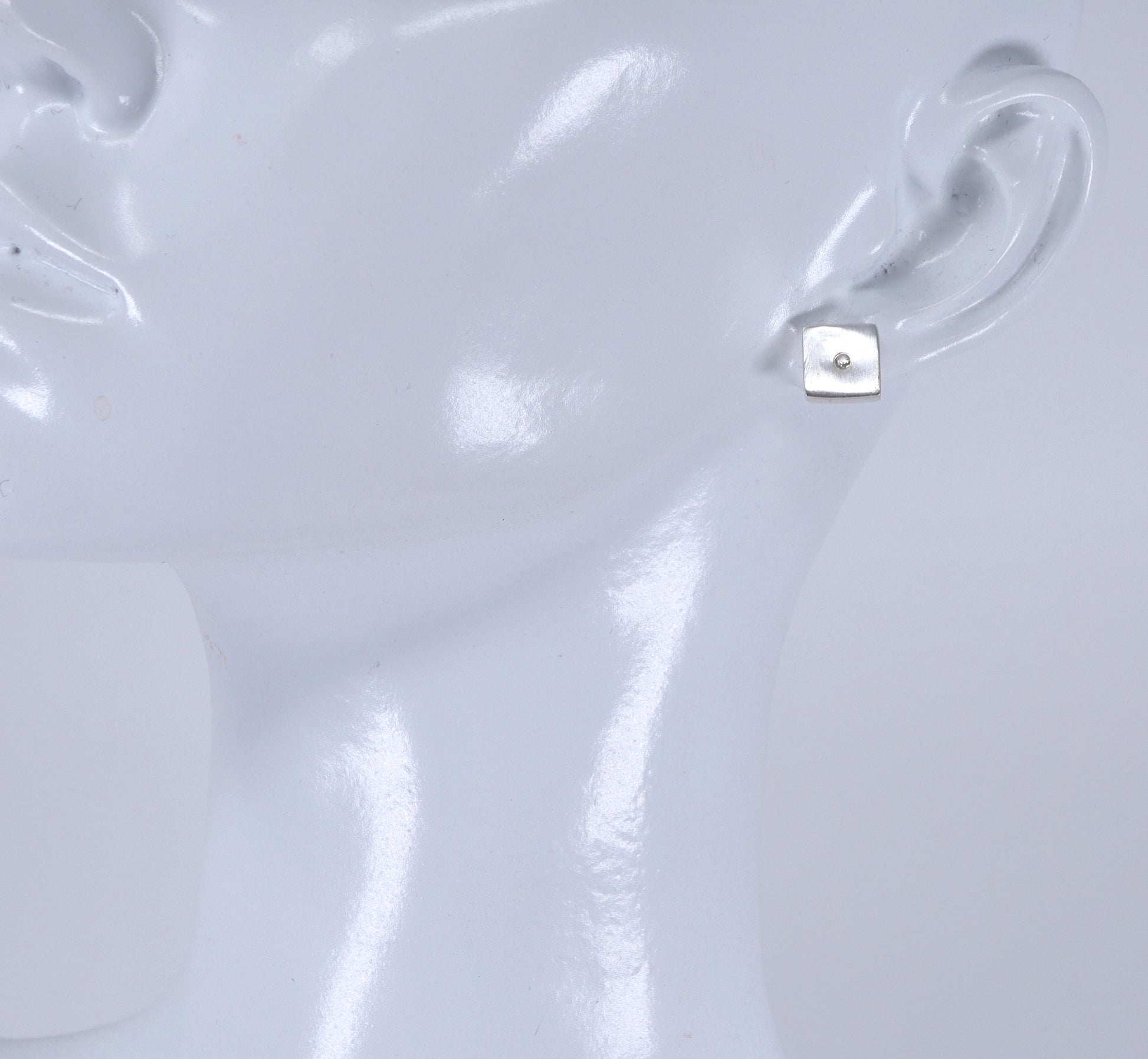 Close-up of a silver earring on a white background