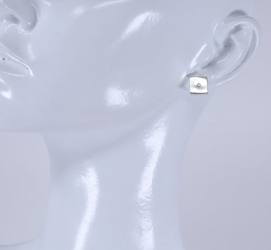 Close-up of a silver earring on a white background