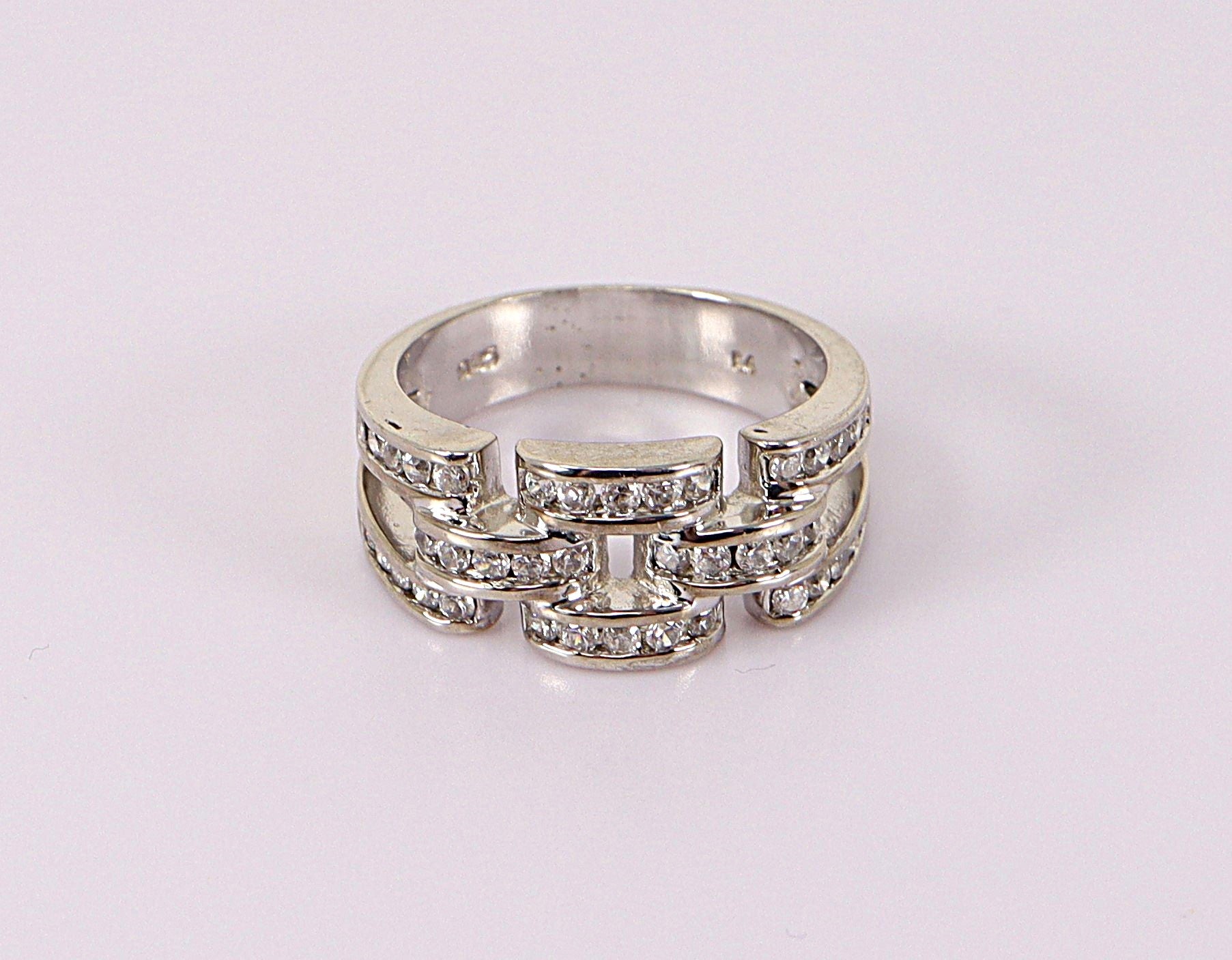 A silver band ring with cubic zirconia gemstones set along the band, viewed from the top on a white background.
