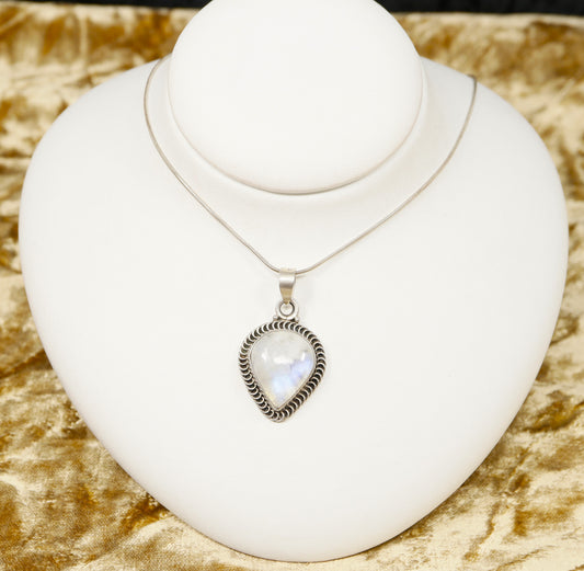 A silver pendant necklace with a large pear shaped moonstone displayed on a mannequin's neck.