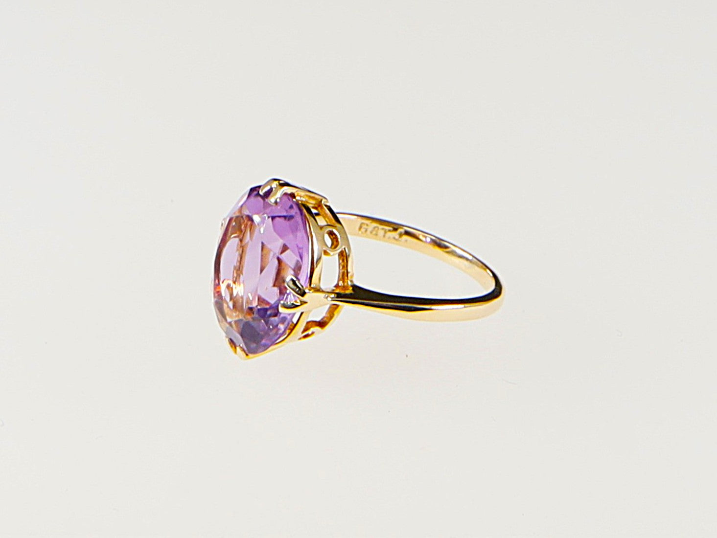 A vintage 9ct gold solitaire ring with a large amethyst gemstone, featuring a double claw basket setting.