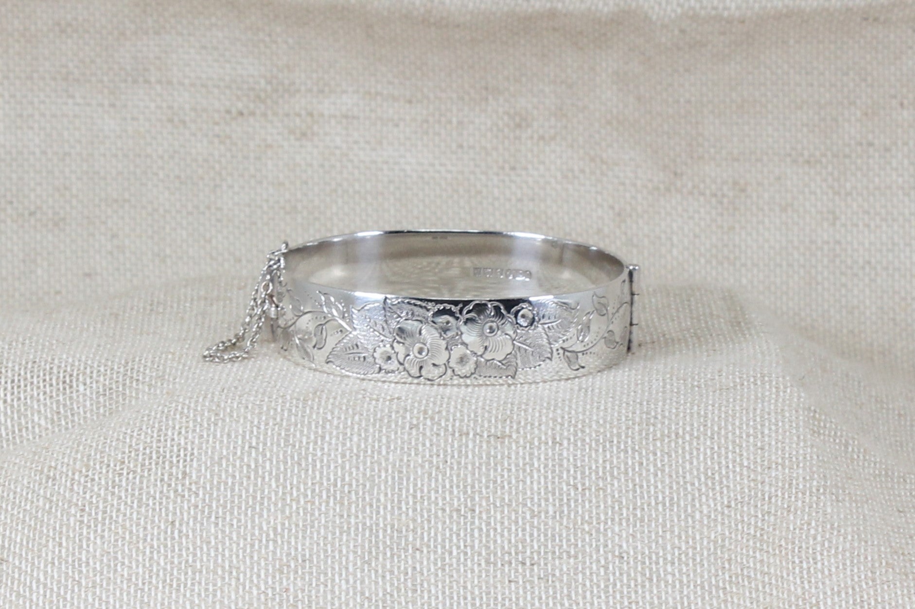 Vintage solid silver hinged bracelet bangle the bracelet has decorative etching on the band a secure clasp and safety chain with Birmingham hallmarks and the date letter for 1974.