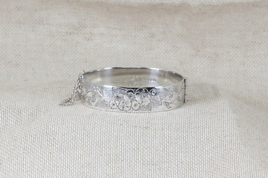 Vintage solid silver hinged bracelet bangle the bracelet has decorative etching on the band a secure clasp and safety chain with Birmingham hallmarks and the date letter for 1974.