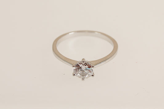 Cubic Zirconia diamond simulant solitaire ring on a light beige background