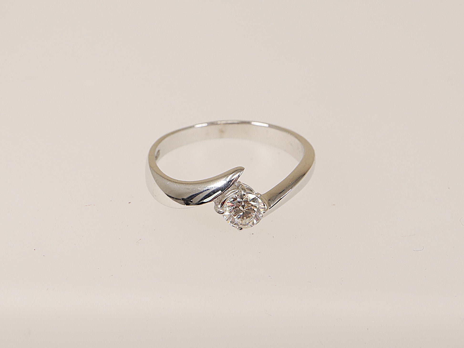 An 18ct white gold diamond solitaire ring with a twist design and a central diamond held by a four claw setting. is the perfect engagement ring! UK Finger size R. Diamond weight: 0.45ct (estimated).