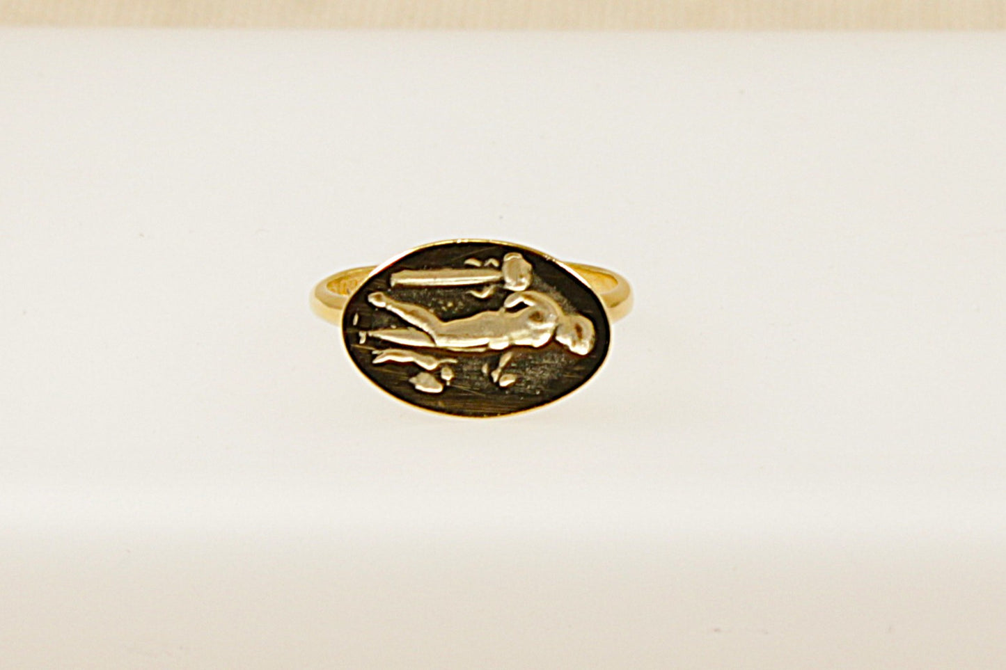 A vintage silver intaglio ring with a classical figure design carved into the top, displayed against a white background.