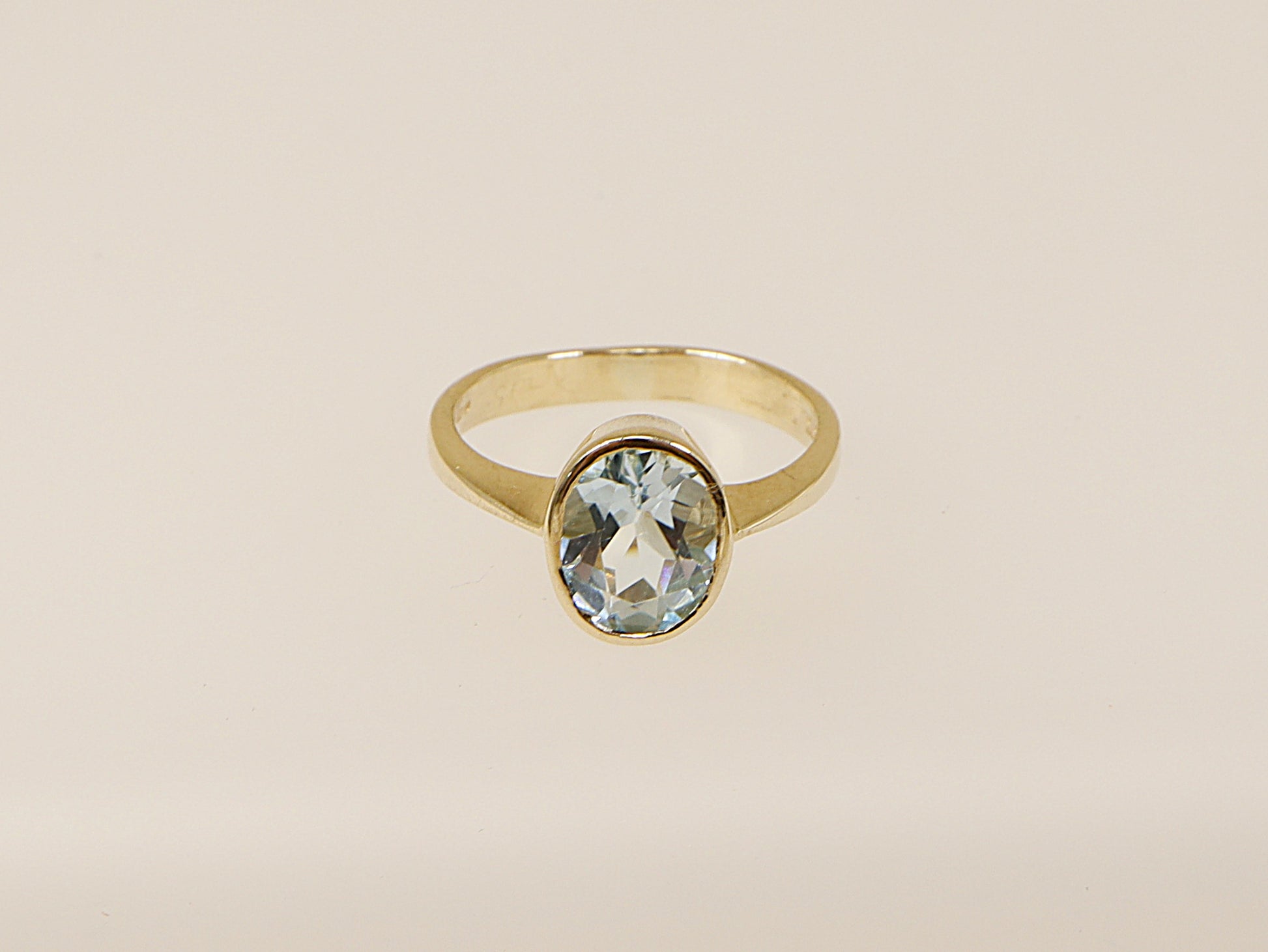 A vintage 9ct gold solitaire ring with an oval-cut blue topaz gemstone.