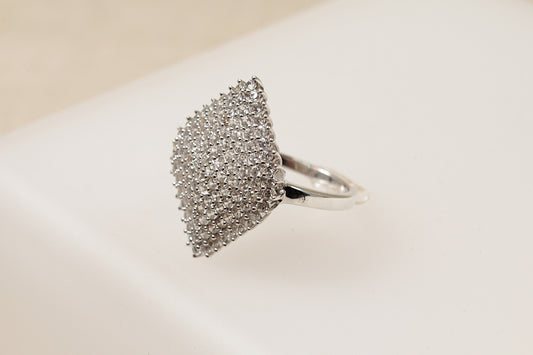 A silver cluster statement ring with a marquise shape and a pave set of white topaz gemstones on a white background.